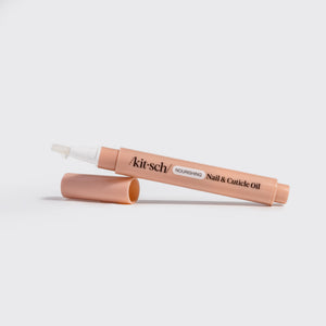 KITSCH Nourishing Nail & Cuticle Oil - Honey & Milk — angled peach pen with cap off showing the white brush tip on a white background — Compact and travel-friendly — cuticle care at home, at work, or on the go
