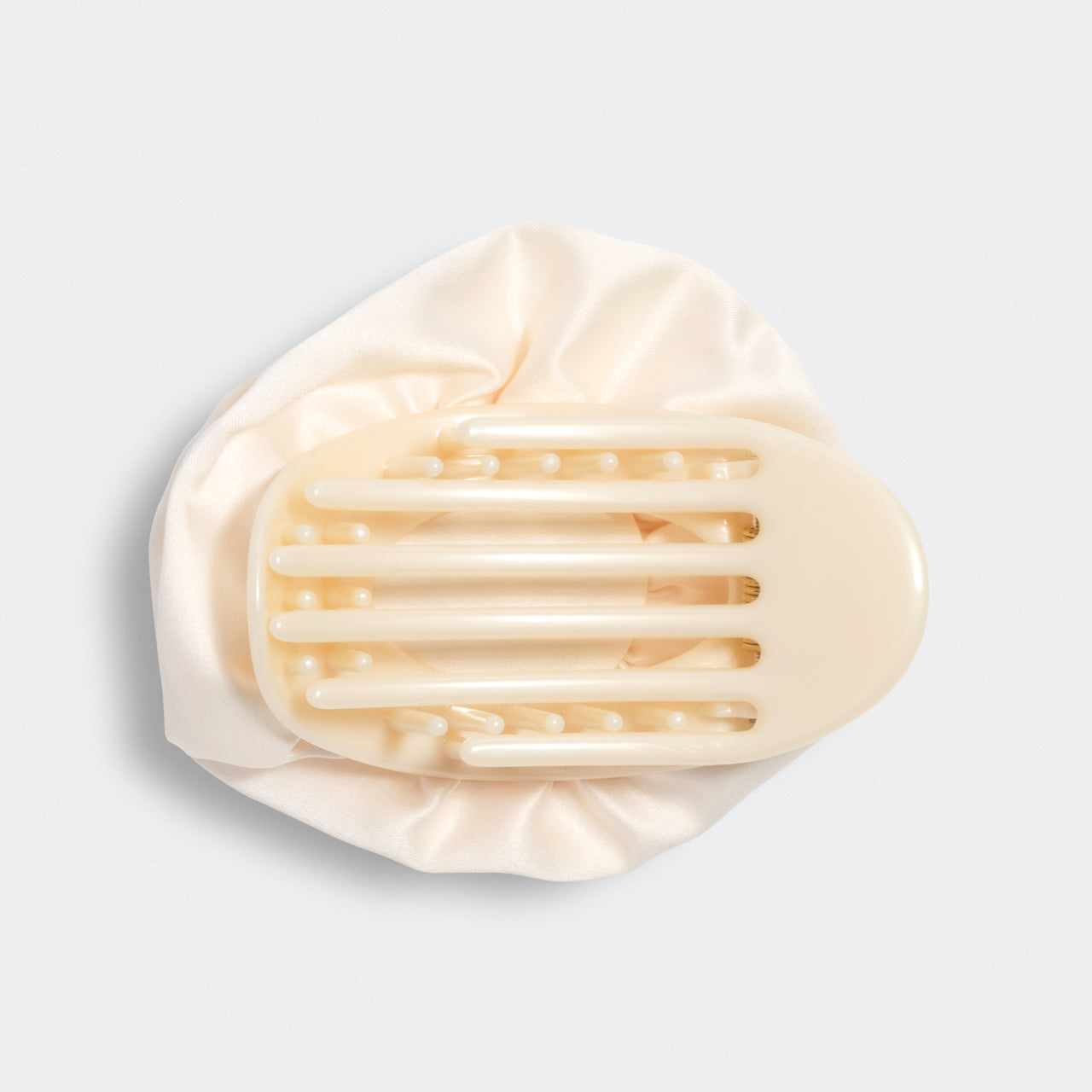 Cream hair clip on a light gray background